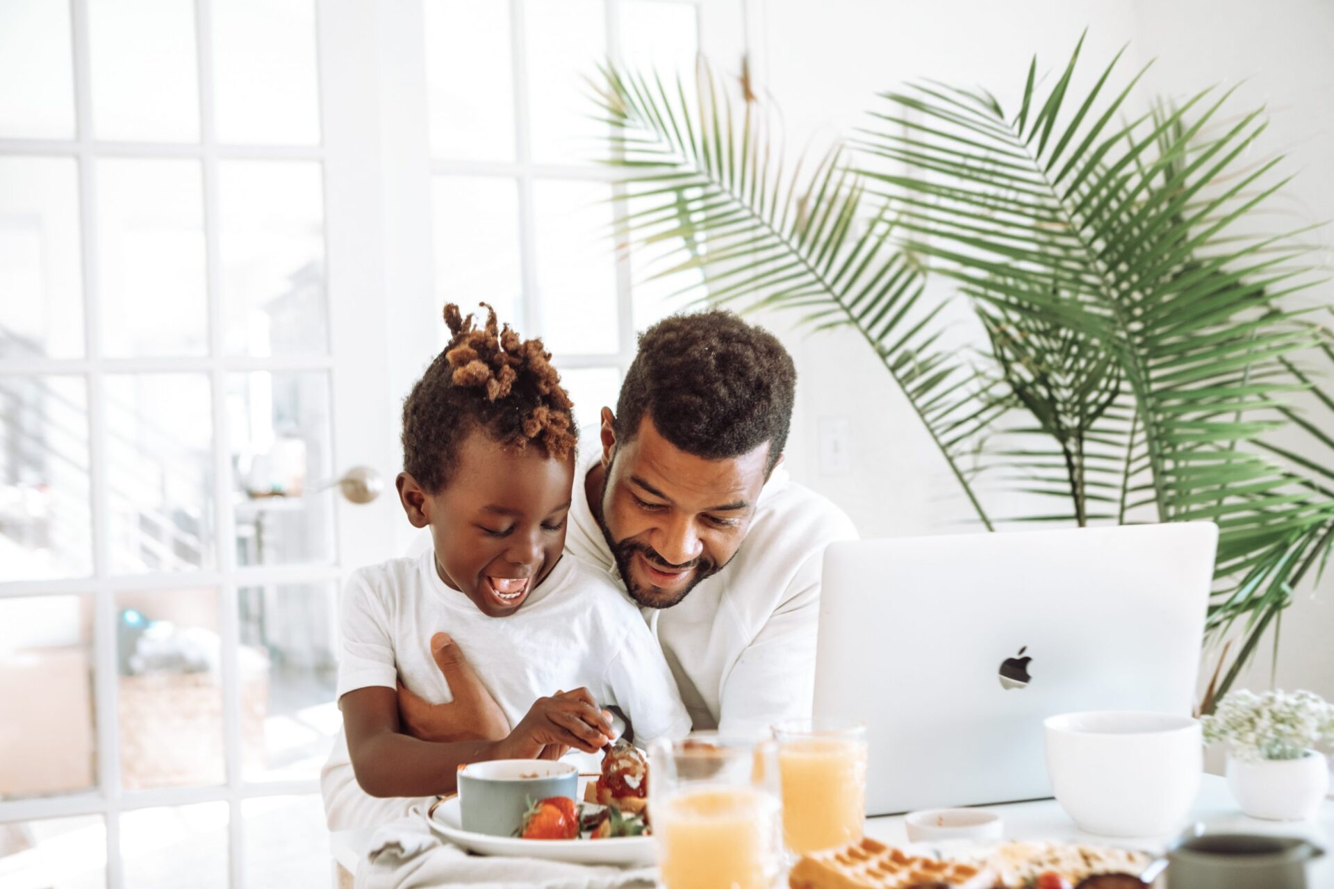 man sitting with son at breakfast table