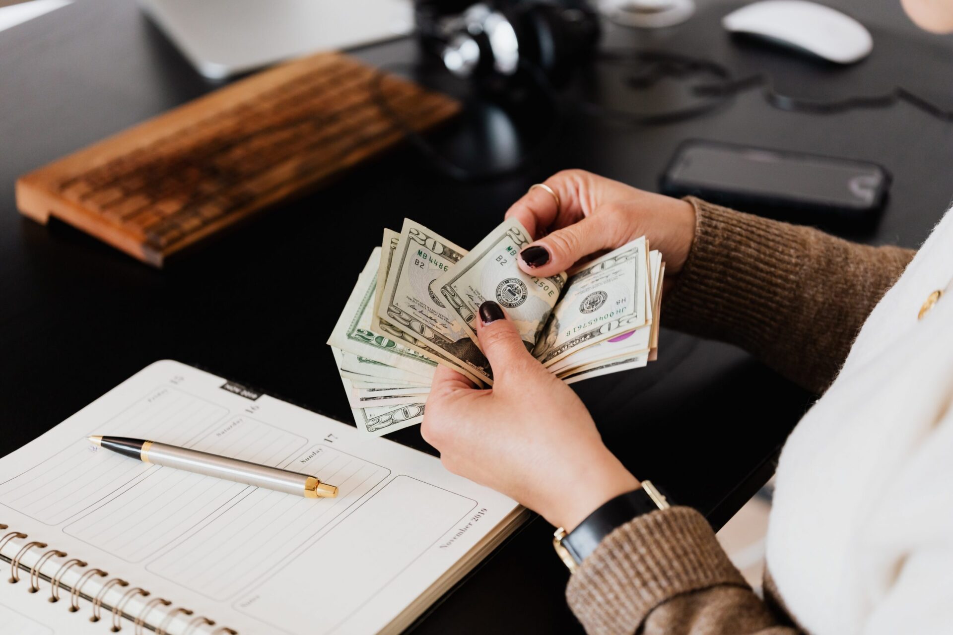 Woman counting cash at her desk