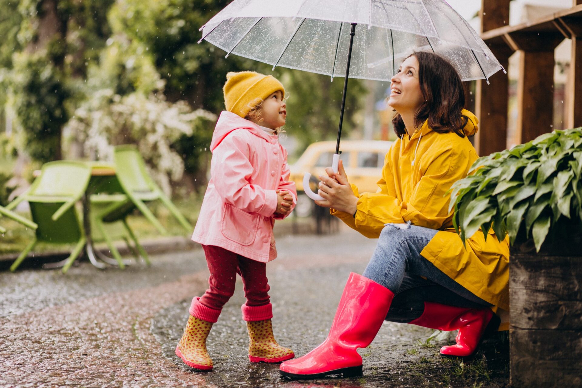 Mother with daughter playing in the rain