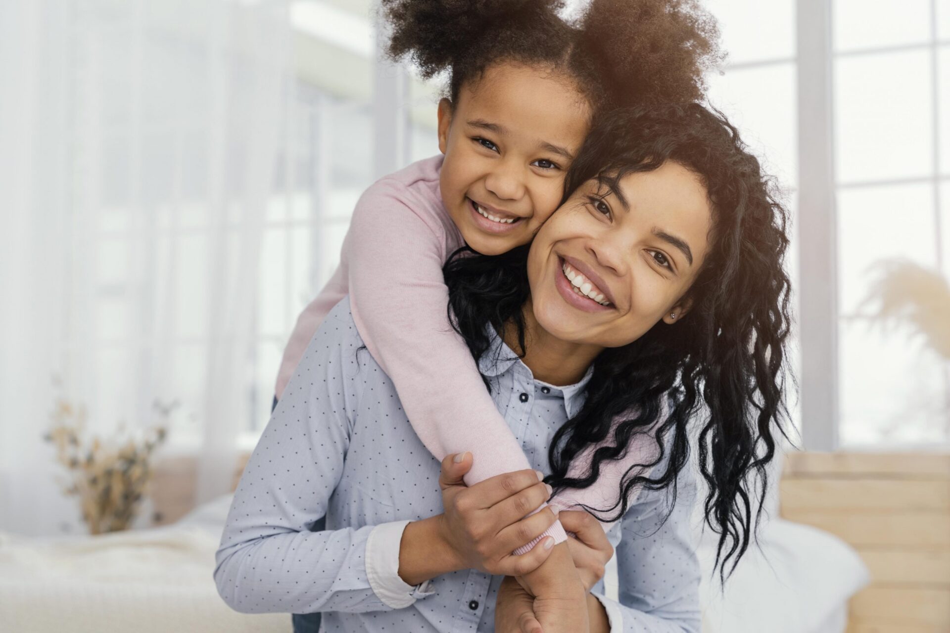 woman holding child across her shoulders