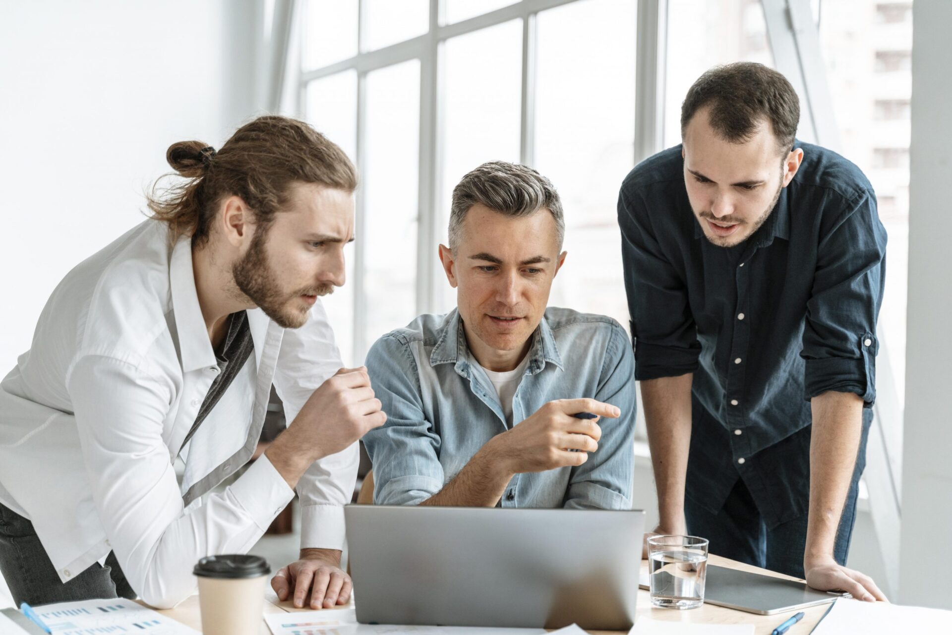 Three men meeting in conference room to talk about business plan