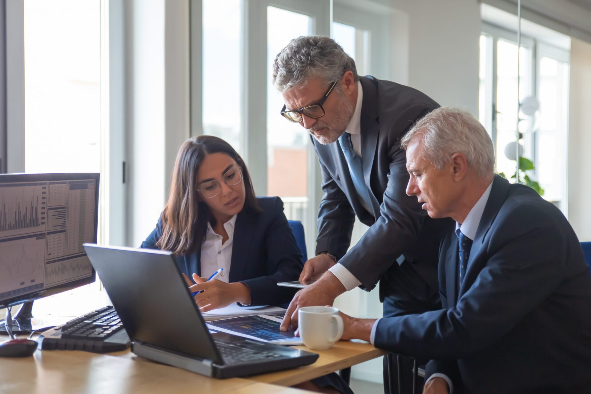 Concentrated colleagues watching statistic charts and talking Partners meeting in conference room to talk about financials