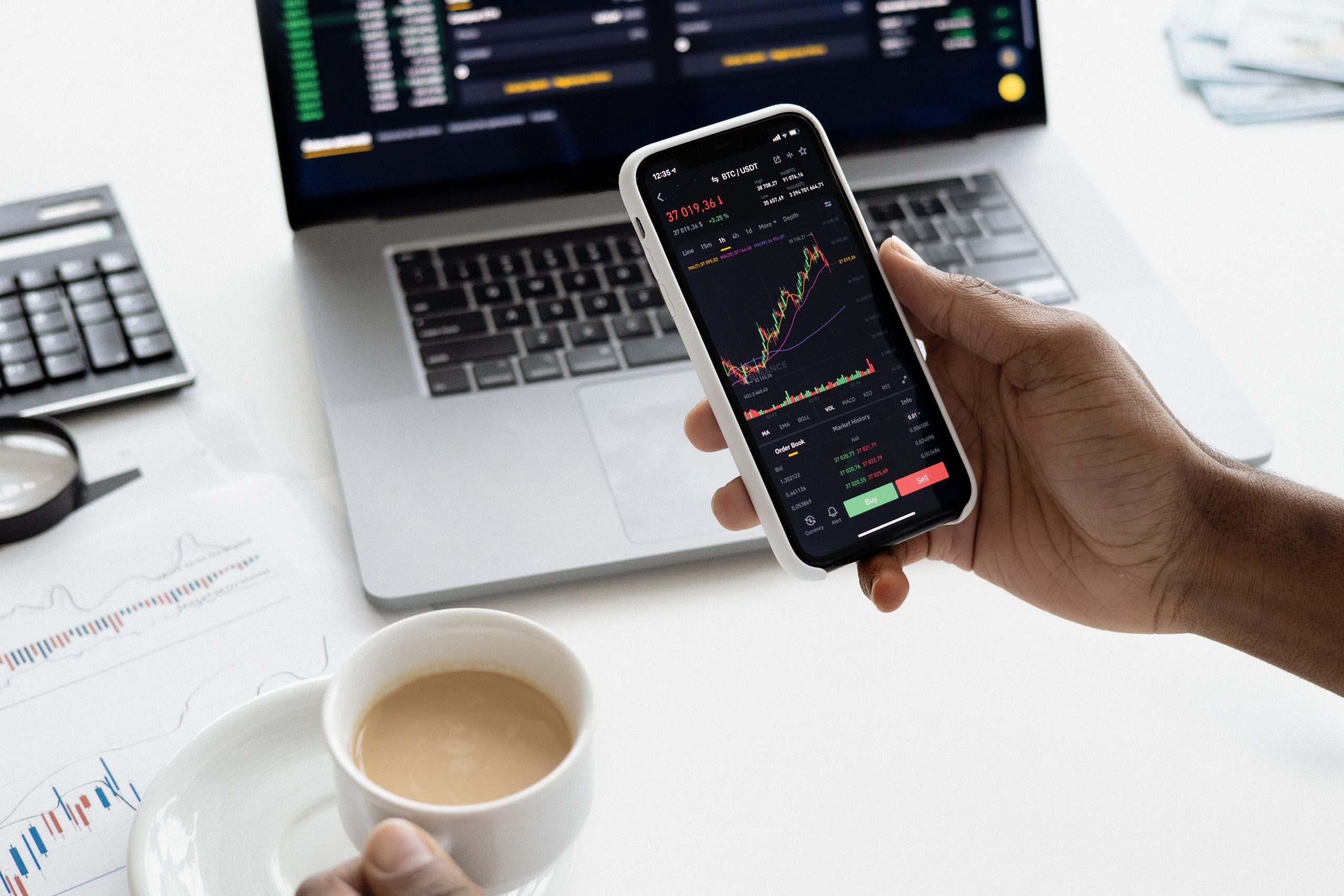 Employee checking on stocks on their phone and computer