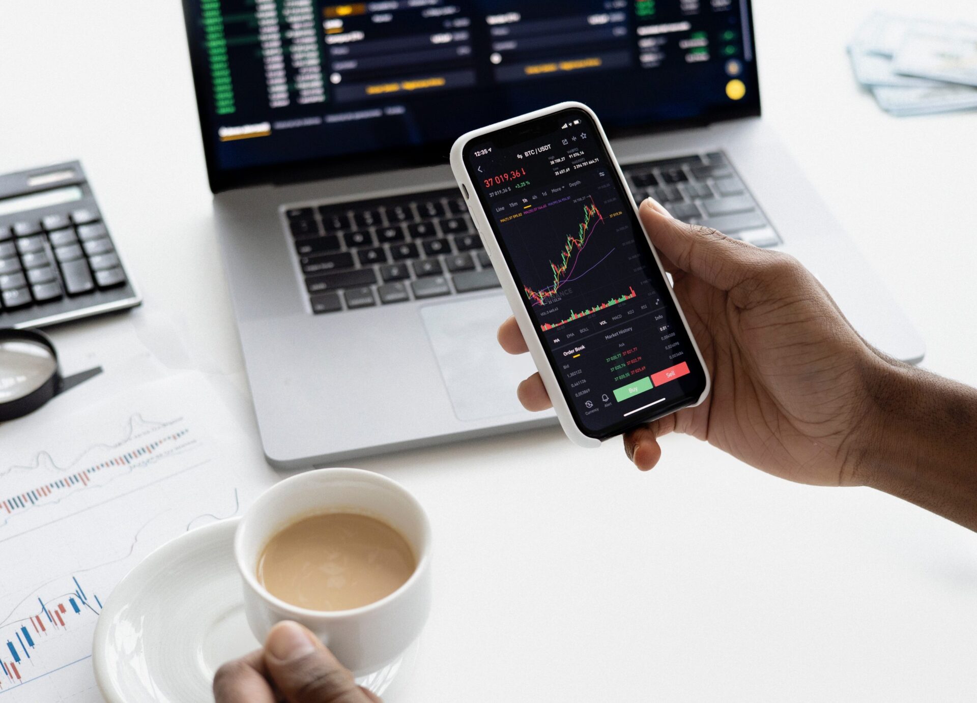Employee checking on stocks on their phone and computer