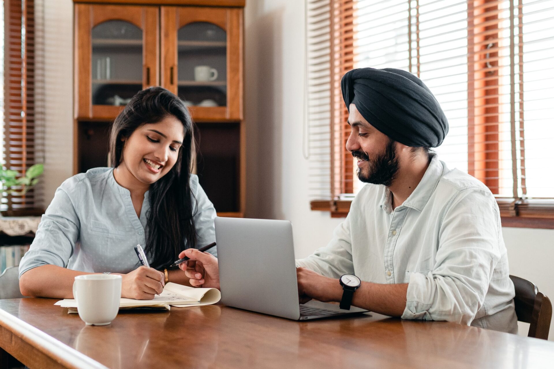 ethnic couple working together on dinner table